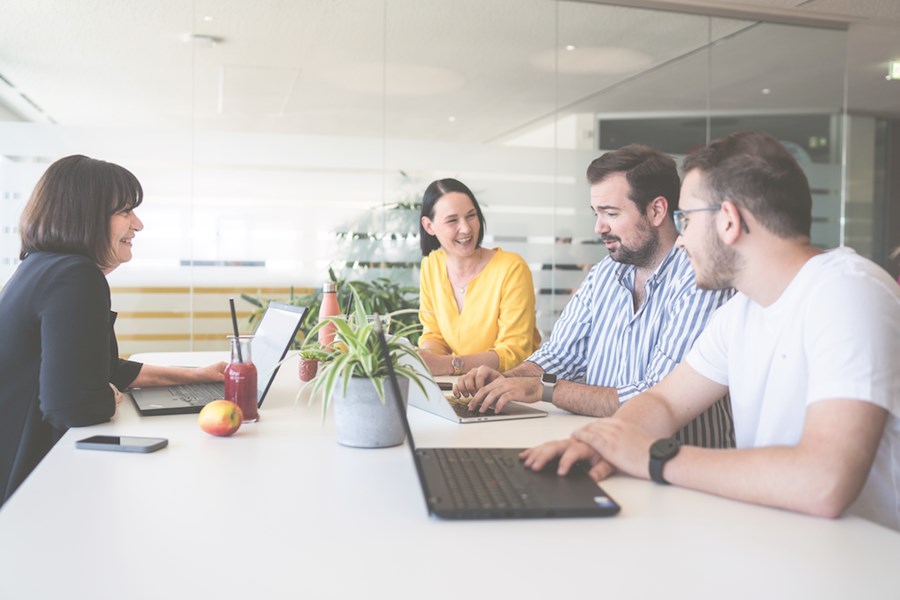 4 Menschen sitzen an einem Tisch 
